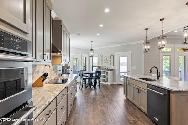 kitchen with dishwashing machine, sink, pendant lighting, a center island with sink, and stainless steel oven