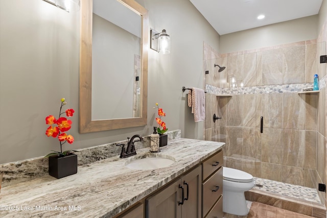 bathroom with walk in shower, vanity, and toilet