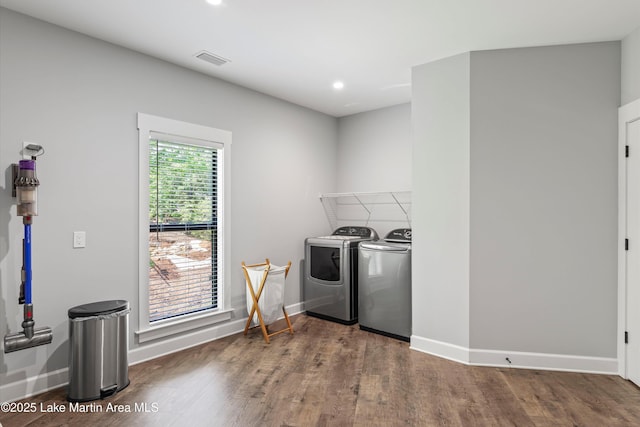 washroom with dark wood-type flooring and washer and clothes dryer