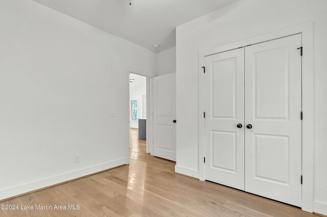 unfurnished bedroom featuring light wood-type flooring and a closet