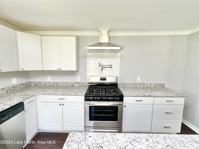 kitchen featuring appliances with stainless steel finishes, dark hardwood / wood-style flooring, white cabinetry, and extractor fan