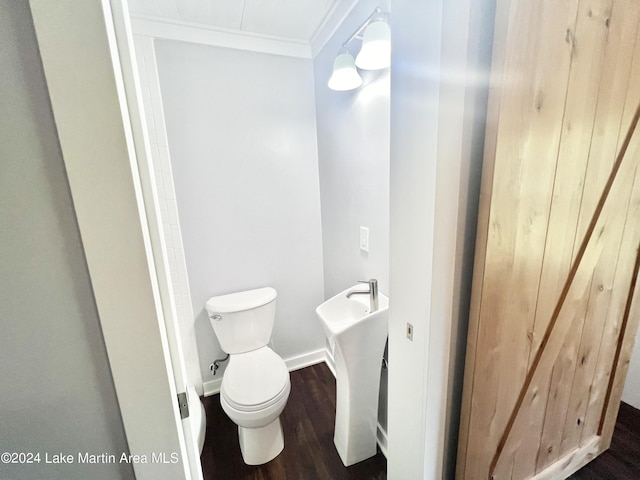 bathroom with hardwood / wood-style flooring, toilet, and ornamental molding