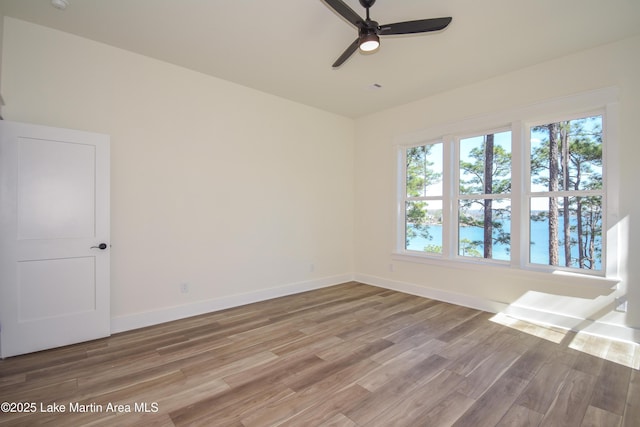 spare room with a ceiling fan, baseboards, and wood finished floors