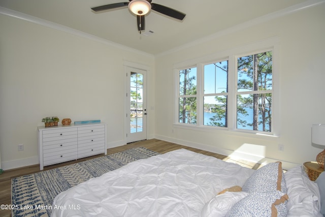 bedroom with wood finished floors, visible vents, baseboards, access to outside, and crown molding