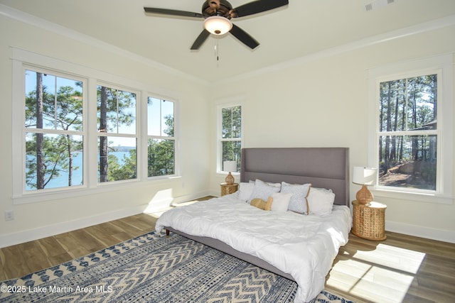 bedroom featuring ornamental molding, baseboards, and wood finished floors