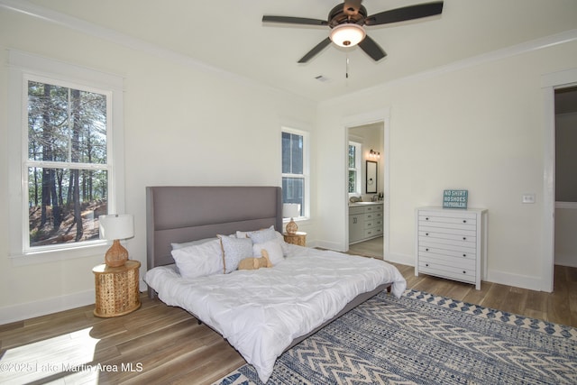 bedroom featuring baseboards, ornamental molding, and wood finished floors