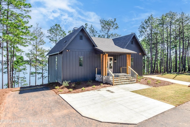 modern inspired farmhouse featuring board and batten siding, roof with shingles, and a porch