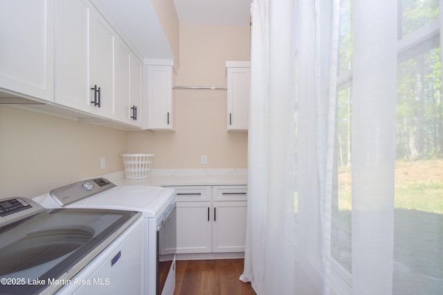 laundry room with washing machine and dryer, cabinet space, and dark wood-style floors