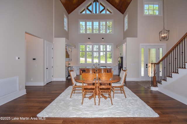 dining room featuring baseboards, visible vents, dark wood-style floors, and high vaulted ceiling