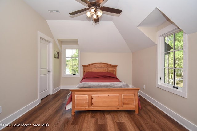 bedroom with multiple windows, lofted ceiling, visible vents, and dark wood finished floors
