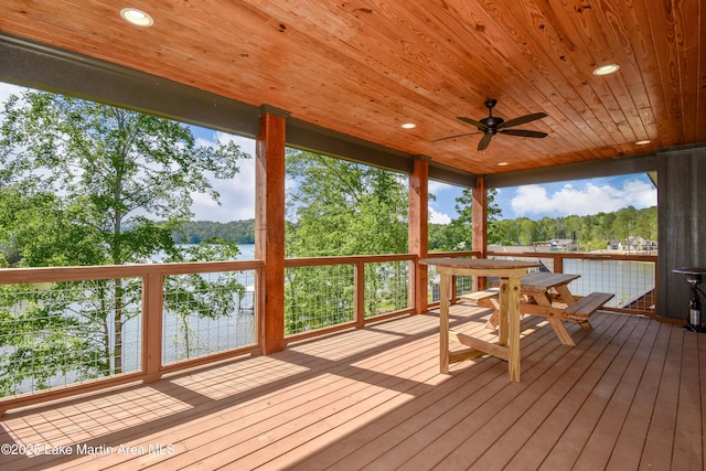 unfurnished sunroom with a water view, a ceiling fan, and a healthy amount of sunlight
