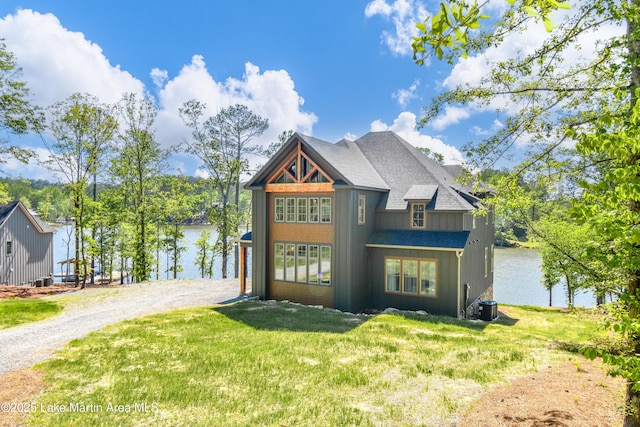 view of front facade with a water view, a front yard, and driveway