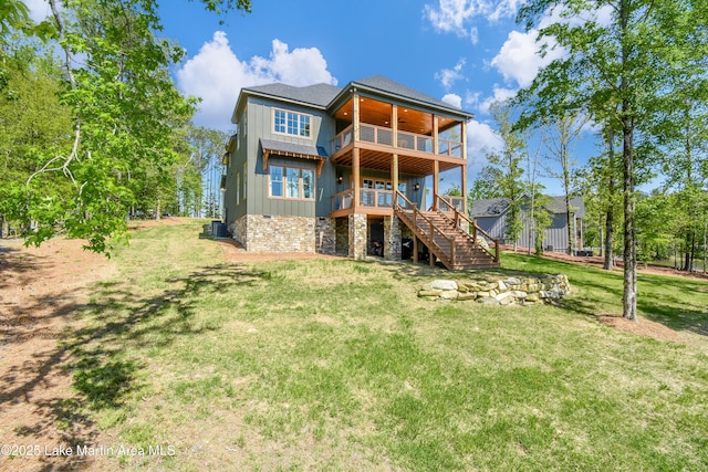 back of property featuring a balcony, a yard, board and batten siding, central AC, and stairs