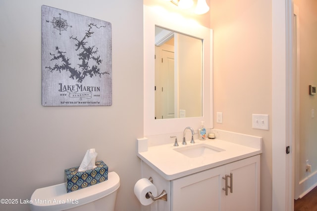 half bath featuring vanity and toilet