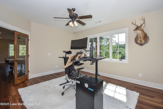 exercise room featuring baseboards, a ceiling fan, visible vents, and wood finished floors