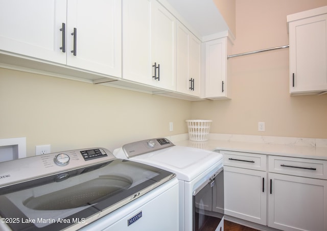 washroom with cabinet space and washing machine and clothes dryer