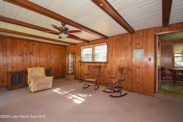 unfurnished room with beamed ceiling, carpet, and wooden walls