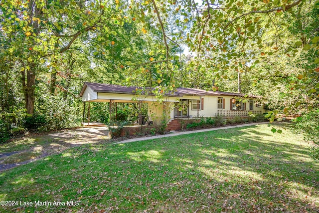 view of front of house featuring a carport, covered porch, and a front lawn