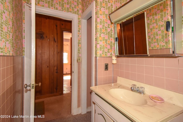 bathroom with vanity and tile walls