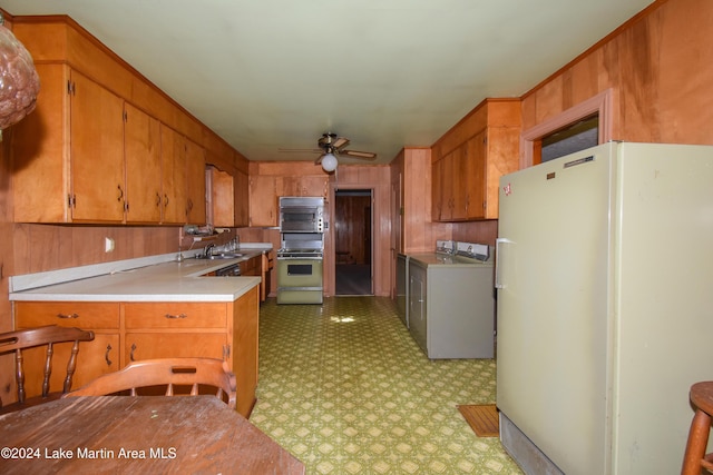 kitchen featuring sink, stainless steel appliances, and wood walls