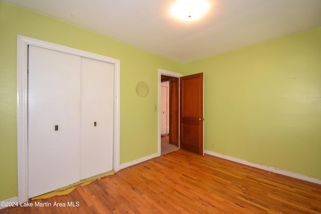 unfurnished bedroom featuring a closet and wood-type flooring