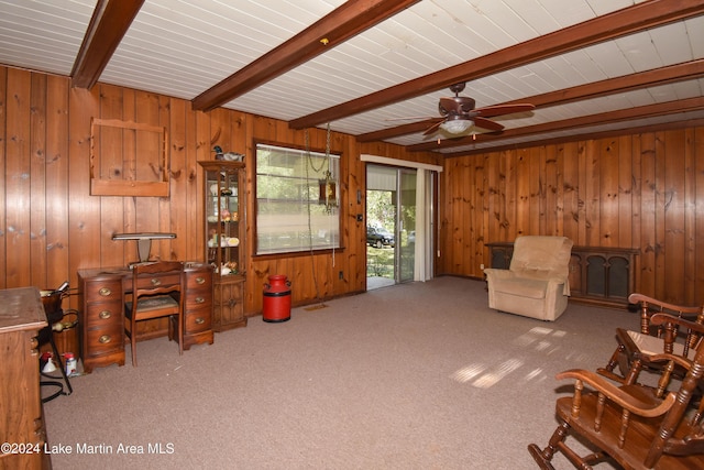 interior space with wood walls, beamed ceiling, and light colored carpet