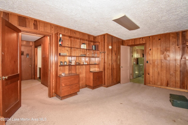 interior space with a textured ceiling and wooden walls