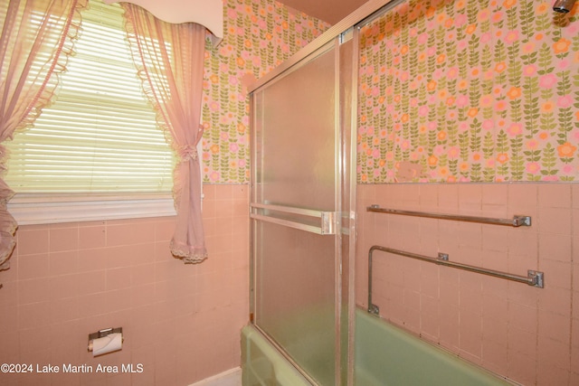 bathroom featuring tile walls and enclosed tub / shower combo