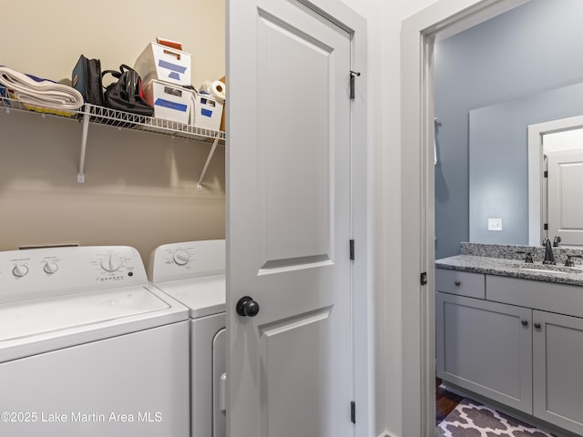 laundry area featuring washing machine and clothes dryer and sink