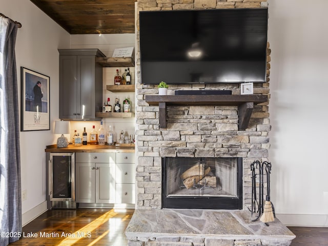 bar with wine cooler, wooden counters, wooden ceiling, dark hardwood / wood-style floors, and a fireplace