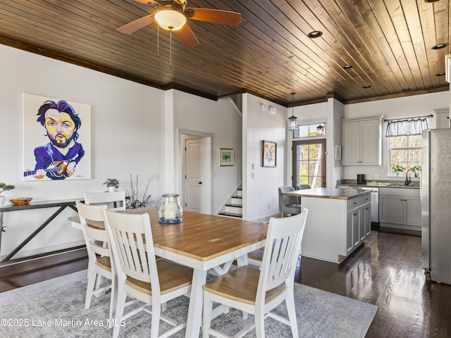 dining room with sink, dark hardwood / wood-style flooring, ornamental molding, ceiling fan, and wood ceiling