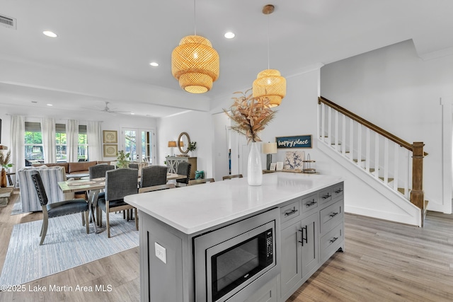 285 Magnolia Way, Dadeville, AL 36853 - kitchen featuring stainless steel microwave, gray cabinetry, light wood-style floors, light countertops, and recessed lighting
