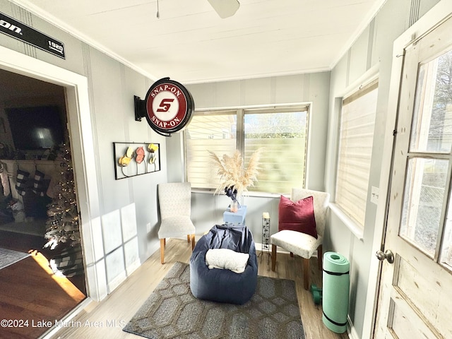 living area featuring light hardwood / wood-style flooring and crown molding