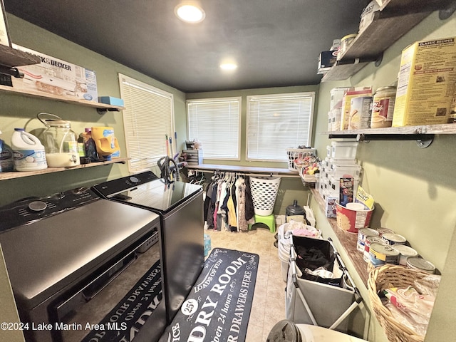 clothes washing area with light tile patterned floors and washing machine and dryer