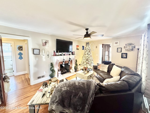 living room with ceiling fan, a fireplace, and hardwood / wood-style flooring