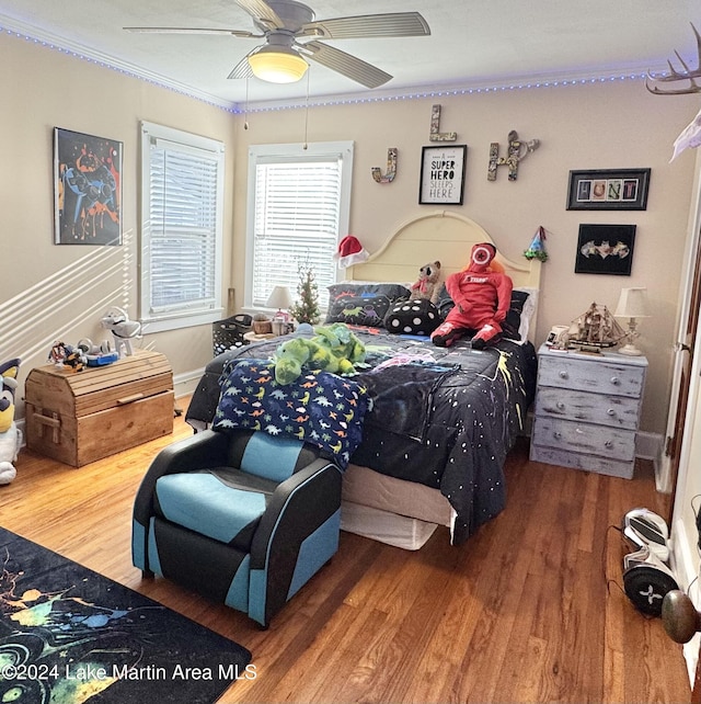 bedroom featuring hardwood / wood-style flooring, ceiling fan, and ornamental molding