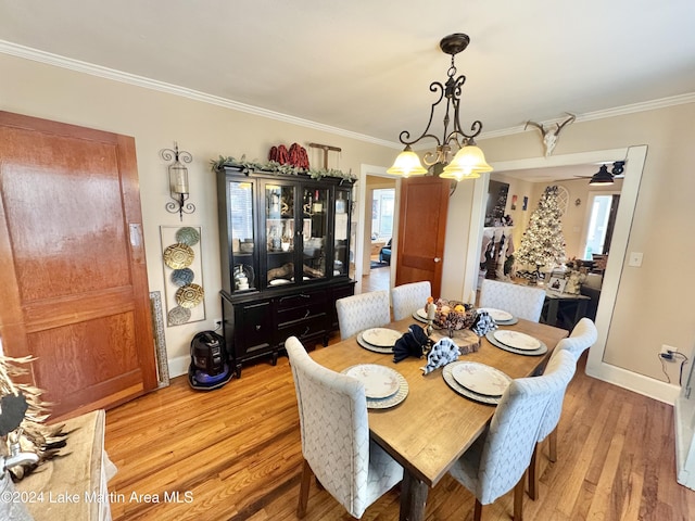 dining room featuring ceiling fan with notable chandelier, light hardwood / wood-style floors, a wealth of natural light, and ornamental molding