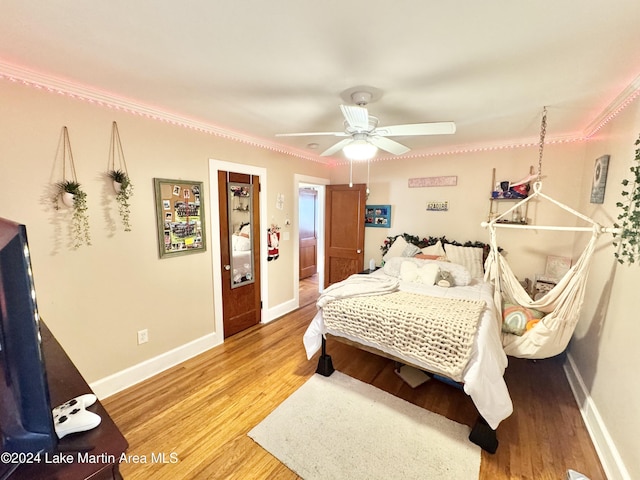 bedroom featuring ceiling fan, hardwood / wood-style floors, and ornamental molding