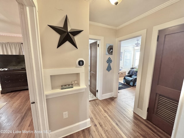 hall with wood-type flooring and crown molding