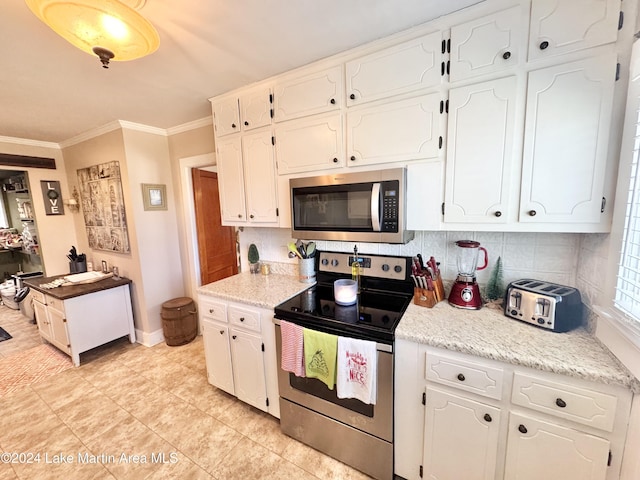 kitchen with white cabinets, appliances with stainless steel finishes, tasteful backsplash, and crown molding