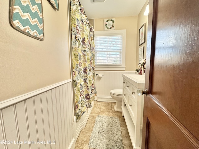 full bathroom with shower / bathtub combination with curtain, vanity, and toilet