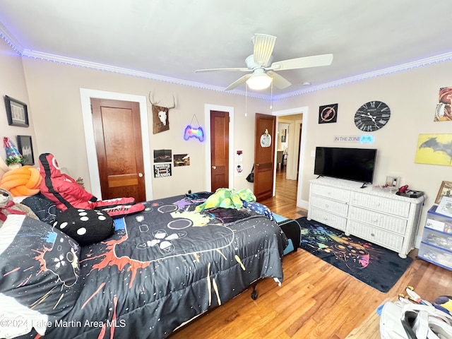 bedroom with ceiling fan, wood-type flooring, and ornamental molding