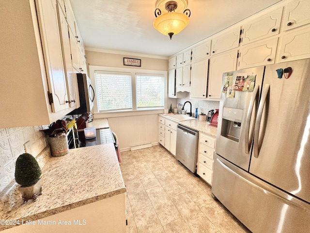 kitchen featuring crown molding, sink, appliances with stainless steel finishes, tasteful backsplash, and white cabinetry