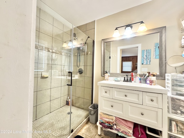 bathroom featuring tile patterned flooring, vanity, and a shower with shower door