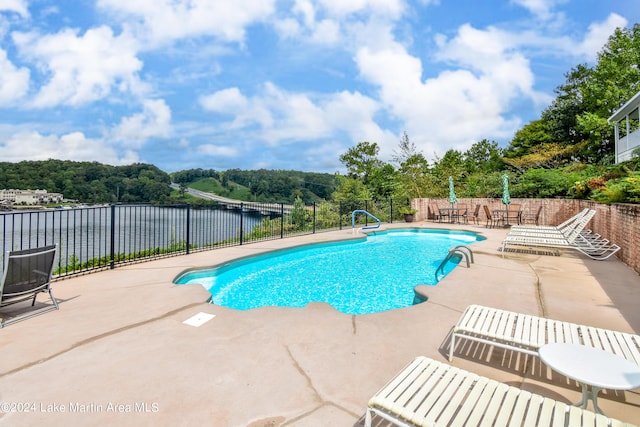 view of pool with a patio area and a water view