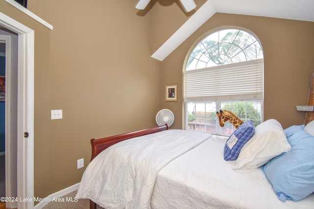 bedroom with ceiling fan, vaulted ceiling, and multiple windows