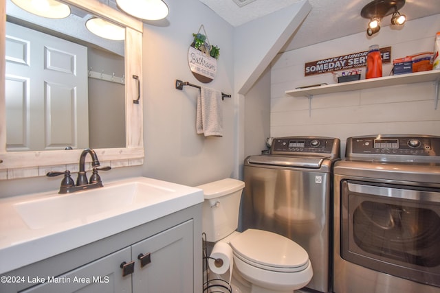 bathroom with vanity, toilet, independent washer and dryer, and a textured ceiling