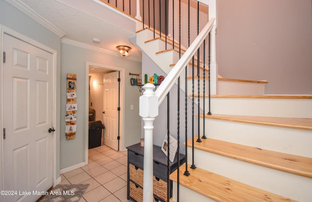 stairs featuring tile patterned flooring and crown molding