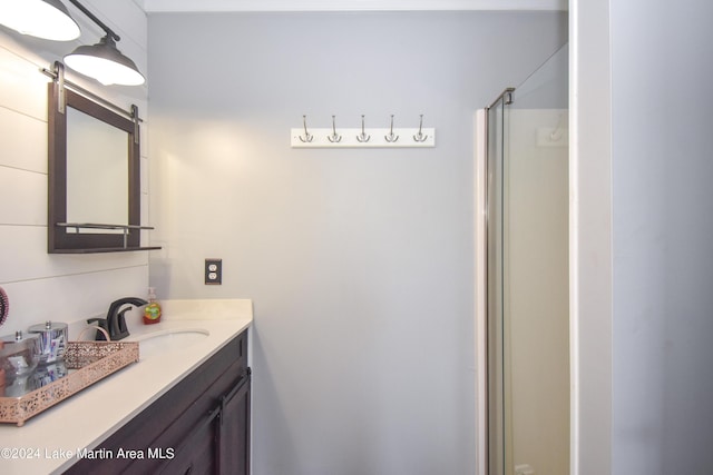 bathroom featuring vanity and a shower with shower door