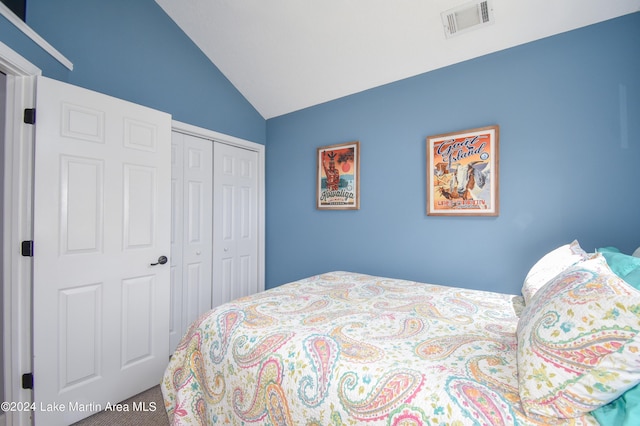 bedroom with carpet flooring, vaulted ceiling, and a closet